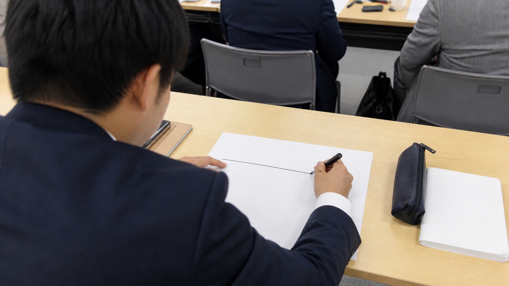 チャットボット導入で自動化する範囲の線引きを紙に書き込む社員
