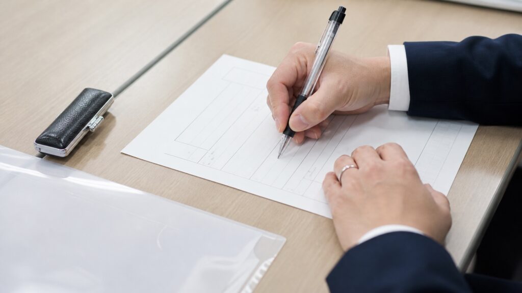 AI研修の助成金の申請書類に記入する手元